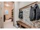 Mud room with bench seating, coat rack, and built in shelving and cabinets at 9521 Garnett Way, Arvada, CO 80007