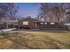 Inviting front exterior of a brick home featuring manicured lawn and mature trees at dusk at 1004 W Shepperd Ave, Littleton, CO 80120