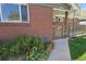 Charming brick home with a manicured lawn, flowerbed and sidewalk leading to the front door at 1004 W Shepperd Ave, Littleton, CO 80120