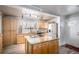 Bright kitchen with wood cabinets, granite counters, stainless steel appliances, and central island cooktop at 1004 W Shepperd Ave, Littleton, CO 80120