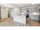 Open kitchen layout with stainless appliances, a central island, and wood-style flooring at 485 Interlocken Blvd # 202, Broomfield, CO 80021