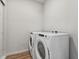 Convenient laundry area featuring a stacked washer and dryer on wood look flooring at 485 Interlocken Blvd # 202, Broomfield, CO 80021