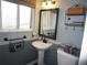 Charming half bath with pedestal sink, decorative mirror, and stylish storage solutions at 12931 W Florida Dr, Lakewood, CO 80228