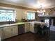 Stylish kitchen with white cabinets, stainless steel dishwasher, and a cozy breakfast nook area with barstool seating at 12931 W Florida Dr, Lakewood, CO 80228