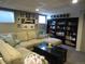 Relaxing finished basement offering a sectional couch, a black coffee table, and dark wood shelving at 12931 W Florida Dr, Lakewood, CO 80228