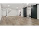 This open basement offers a spacious layout with sleek flooring, barn doors, and ample lighting at 5116 Jellison St, Arvada, CO 80002