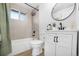 The renovated bathroom has a shower over the tub, updated vanity, and neutral color palette at 5116 Jellison St, Arvada, CO 80002
