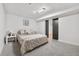 Bedroom with gray carpet, neutral bedding, and black barn doors at 5116 Jellison St, Arvada, CO 80002