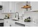 A sleek, modern kitchen counter features white cabinets, stylish fixtures, and a clean, inviting aesthetic at 5116 Jellison St, Arvada, CO 80002