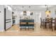 Bright kitchen with island, bar seating, stainless steel appliances, pendant lighting, and white cabinetry at 5116 Jellison St, Arvada, CO 80002