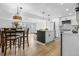 Well-lit kitchen and dining area with a modern island, stainless appliances, and sleek countertops at 5116 Jellison St, Arvada, CO 80002
