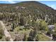 Expansive aerial view of a tree-filled community with houses nestled in the landscape at 9359 Barnes Ave, Conifer, CO 80433