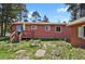Backyard exterior view of the house including a deck and an expansive lawn at 9359 Barnes Ave, Conifer, CO 80433