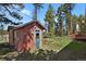 Charming home exterior with a bright blue door and a cozy, natural yard at 9359 Barnes Ave, Conifer, CO 80433