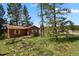 Cozy cabin-style home featuring wood siding, green shutters, and a well-maintained yard at 9359 Barnes Ave, Conifer, CO 80433