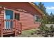 Charming home exterior featuring a blue front door, wood siding, and well-maintained landscaping at 9359 Barnes Ave, Conifer, CO 80433