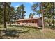 Charming exterior view of a single-Gathering home surrounded by mature trees and a well-manicured lawn at 9359 Barnes Ave, Conifer, CO 80433
