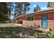 Inviting home exterior with a blue front door, stone accents, and lush landscaping at 9359 Barnes Ave, Conifer, CO 80433
