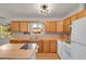 Bright kitchen featuring wood cabinets, white appliances, and an island for extra counter space at 9359 Barnes Ave, Conifer, CO 80433