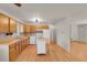 Open kitchen with wood cabinetry, white appliances, and hardwood flooring offering a functional space at 9359 Barnes Ave, Conifer, CO 80433