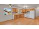 Well-lit kitchen with wood cabinets, white appliances, and views of the surrounding nature at 9359 Barnes Ave, Conifer, CO 80433