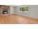 Spacious living room with hardwood floors, a brick fireplace, and ample natural light at 9359 Barnes Ave, Conifer, CO 80433