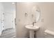 Elegant powder room with pedestal sink, oval mirror, and modern fixtures at 1296 S Algonquian, Aurora, CO 80018