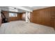 Finished basement featuring wood paneling, carpet flooring and a staircase at 1539 S Quail St, Denver, CO 80232