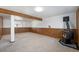 Spacious basement area featuring wood paneling, fireplace and carpet flooring at 1539 S Quail St, Denver, CO 80232