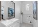 Clean bathroom with white vanity, gray patterned floor, and a window at 4442 Josephine St, Denver, CO 80216