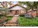 Charming brick home featuring manicured lawn, stone walkway and cozy front porch at 730 Cook St, Denver, CO 80206
