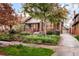 Beautiful brick home with landscaped front yard, mature trees, and inviting front porch at 730 Cook St, Denver, CO 80206