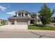 Charming two-story home featuring a three-car garage, well-manicured lawn, and mature tree providing shade at 1881 Alma Ln, Superior, CO 80027