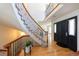 Inviting foyer with wood floors, curved staircase with iron railings, and a view into the living room at 1881 Alma Ln, Superior, CO 80027