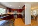 Updated kitchen with dark wood cabinets, stainless steel appliances, granite countertops, and light wood flooring at 1881 Alma Ln, Superior, CO 80027