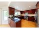 Updated kitchen with dark wood cabinetry, stainless steel appliances, granite countertops, and wood flooring at 1881 Alma Ln, Superior, CO 80027