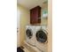 Well-equipped laundry room with modern washer and dryer, cabinet storage, and tiled flooring at 1881 Alma Ln, Superior, CO 80027