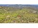 Aerial view of the mountain home nestled in the woods with winding roads at 11333 Conifer Mountain Rd, Conifer, CO 80433