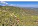 Drone shot reveals a charming home nestled within a dense forest, boasting scenic mountain views and private surroundings at 11333 Conifer Mountain Rd, Conifer, CO 80433