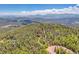 Birds eye view of a house located in a forest, featuring views of the nearby mountains and winding roads at 11333 Conifer Mountain Rd, Conifer, CO 80433