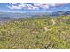 Aerial view of a house surrounded by a forest, with mountain views in the distance at 11333 Conifer Mountain Rd, Conifer, CO 80433