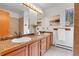 Bright bathroom featuring double sinks, wood cabinets, and neutral tiled flooring at 11333 Conifer Mountain Rd, Conifer, CO 80433