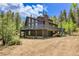 Exterior view of mountain home, showing wooden siding and spacious wooden deck at 11333 Conifer Mountain Rd, Conifer, CO 80433