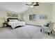 Bright main bedroom features vaulted ceilings, a ceiling fan, carpeted floors, and outside views from two windows at 11333 Conifer Mountain Rd, Conifer, CO 80433