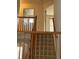 View from the top of the carpeted stairs, showcasing the wooden railing and doors to various rooms at 18336 E Amherst Dr, Aurora, CO 80013
