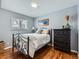 Cozy bedroom showcases hardwood floors, a wrought iron bed frame, and soft, neutral-toned bedding at 469 S Routt Way, Lakewood, CO 80226