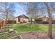 Large fenced backyard with mature trees, garden beds and stone patio at 673 Brentwood St, Lakewood, CO 80214