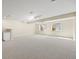 Spacious basement with neutral carpet, two windows, and modern lighting at 673 Brentwood St, Lakewood, CO 80214