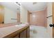 Retro-style bathroom with pink tile, wooden cabinets, and a shower-tub combo at 673 Brentwood St, Lakewood, CO 80214