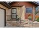 Inviting front porch with brick steps and decorative planters, leading to a secure front door at 673 Brentwood St, Lakewood, CO 80214